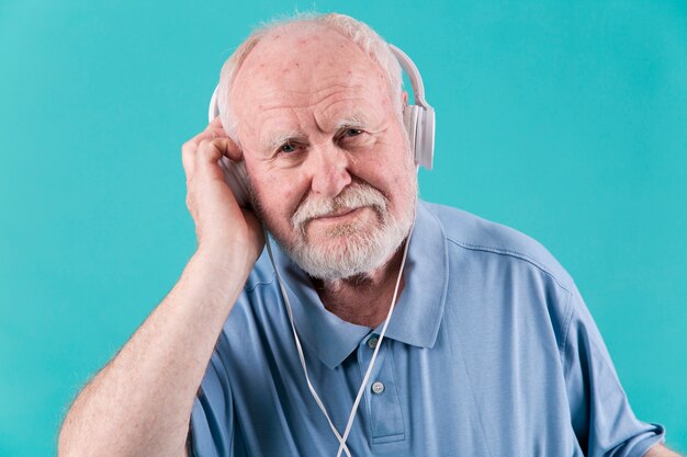 Vista frontal homem sênior com fones de ouvido