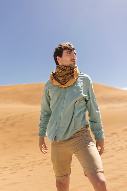 Vista frontal homem usando cachecol no deserto