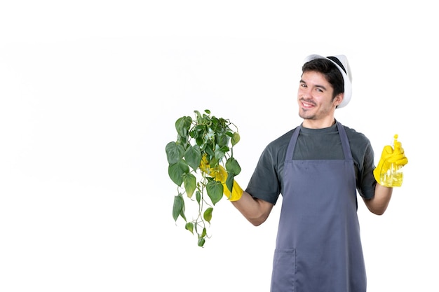 Vista frontal jardineiro masculino segurando planta em vaso e spray em fundo branco árvore de trabalho grama chão trabalho jardim flor arbusto cor