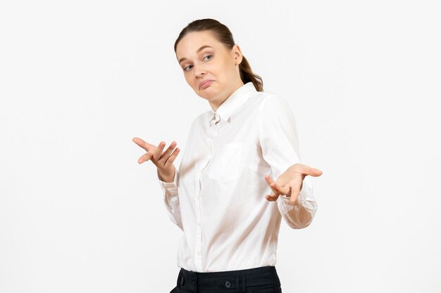 Vista frontal jovem com blusa branca com expressão confusa no fundo branco sentindo modelo trabalho escritório emoção feminino