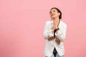 Foto grátis vista frontal jovem com jaqueta branca orando no fundo rosa senhora emoções moda sentimento cor mulher