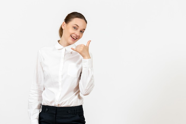 Vista frontal jovem de blusa branca com expressão sorridente no fundo branco, sentimento modelo emprego escritório emoção feminino