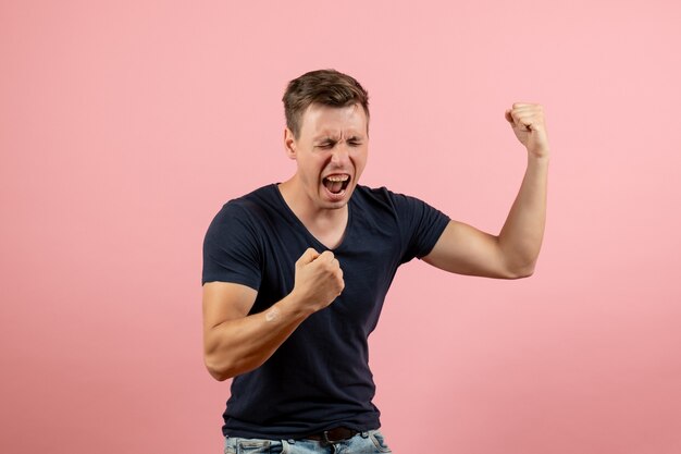 Foto grátis vista frontal jovem do sexo masculino com camisa azul escura emocionalmente regozijando-se com o fundo rosa homem modelo emoção masculino cor humana