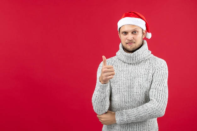 Vista frontal jovem do sexo masculino com camisa quente no fundo vermelho