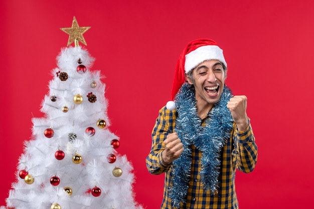 Foto grátis vista frontal jovem do sexo masculino em torno da atmosfera de ano novo no piso vermelho feriado natal humano