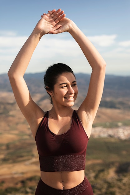 Foto grátis vista frontal jovem e sorridente treinamento de yoga feminino