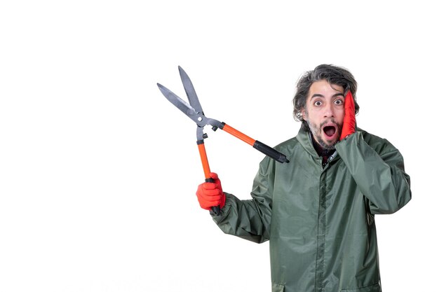 Vista frontal jovem macho segurando tesouras de podar em fundo branco jardineiro flor homem trabalho solo trabalho árvore emoções grama