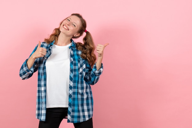 Vista frontal jovem mulher com camisa quadriculada azul, posando com um sorriso no fundo rosa emoção menina modelo moda jovem garoto