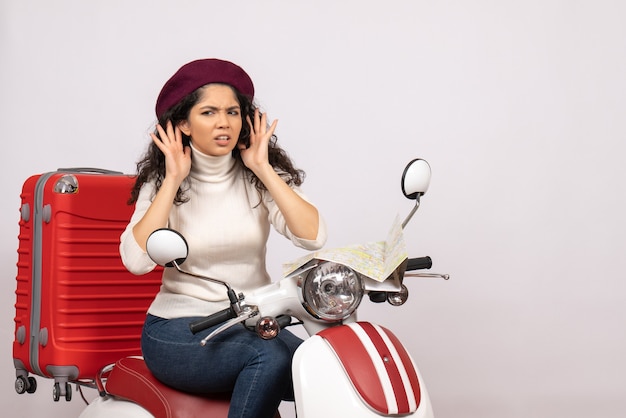 Vista frontal jovem mulher sentada na bicicleta ouvindo no fundo branco cor estrada motocicleta veículo férias mulher cidade