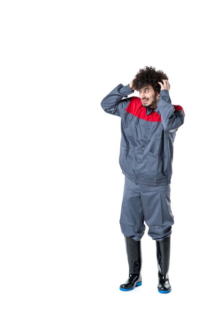 vista frontal jovem trabalhador do sexo masculino de uniforme em fundo branco