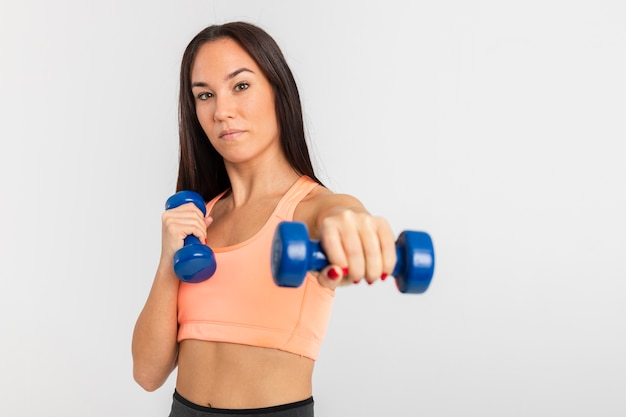 Vista frontal jovem treinamento feminino com pesos