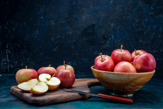 Vista frontal, maçãs vermelhas frescas suculentas e maduras no prato na mesa azul escuro frutas maduras frescas