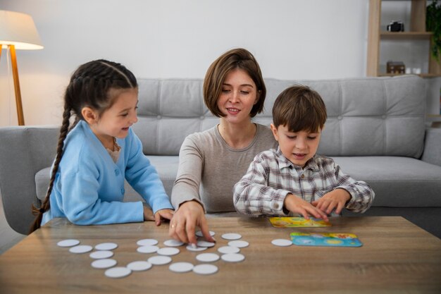 Vista frontal mãe e filhos jogando jogo da memória