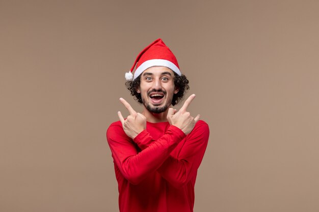 Vista frontal masculino em vermelho com cara feliz em fundo marrom férias emoção natal