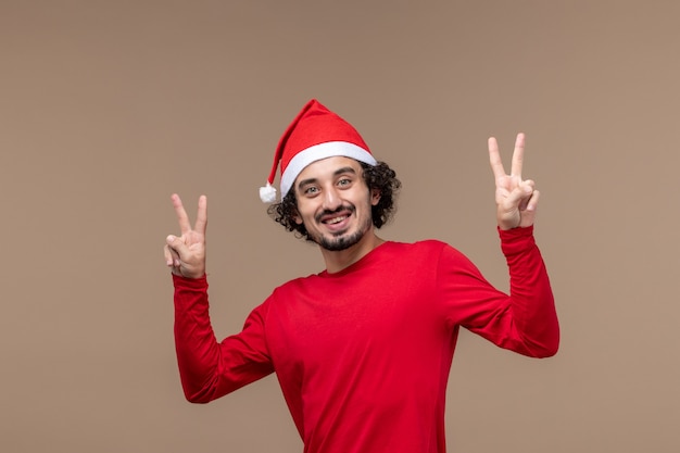 Vista frontal masculino em vermelho com rosto sorridente em fundo marrom férias emoção natal