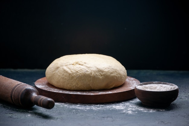 Vista frontal massa crua fresca em torta de bolo escuro cozinhando massa de biscoito