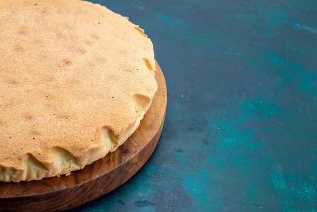 Foto grátis vista frontal massa de bolo simples assada redonda formada na parede azul escura bolo asse torta de massa de açúcar doce