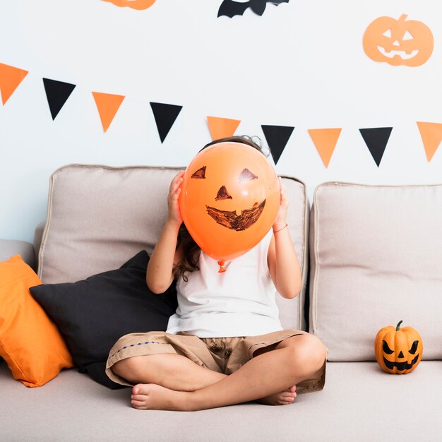 Vista frontal menina segurando um balão de halloween