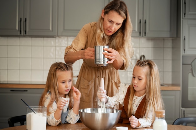 Vista frontal meninas e mulher cozinhando