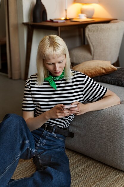 Foto grátis vista frontal mulher albina segurando smartphone