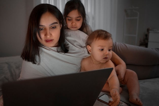 Vista frontal mulher com filhos em casa