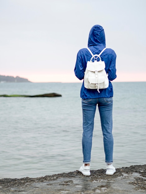 Foto grátis vista frontal mulher com mochila na beira-mar