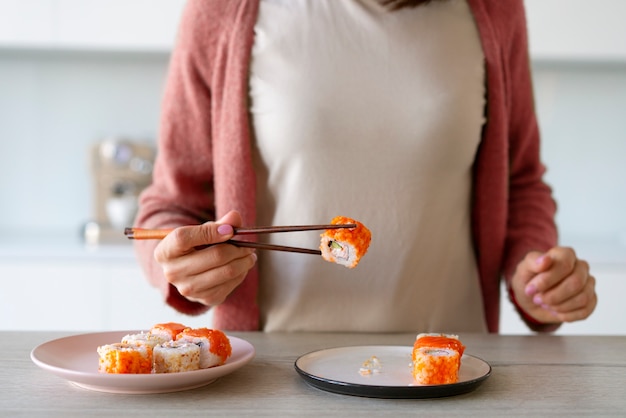 Foto grátis vista frontal mulher comendo sushi em casa