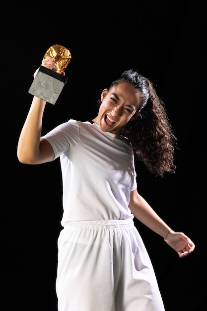 Foto grátis vista frontal mulher feliz futebol com copo