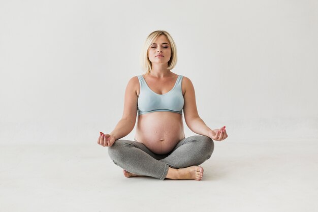 Vista frontal mulher grávida meditando