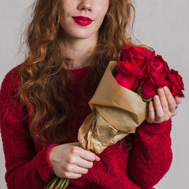 Vista frontal mulher segurando buquê de rosas