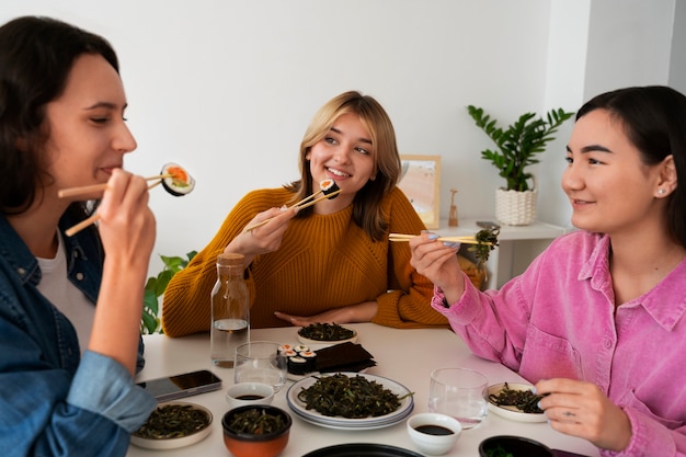 Vista frontal mulheres comendo em casa