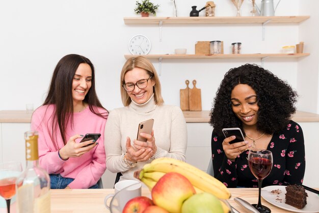 Vista frontal mulheres olhando em seus telefones