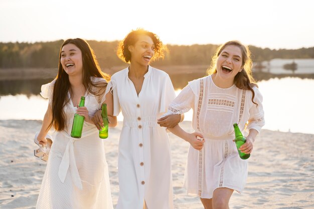Vista frontal mulheres sorridentes na praia