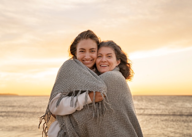 Vista frontal mulheres sorridentes na praia