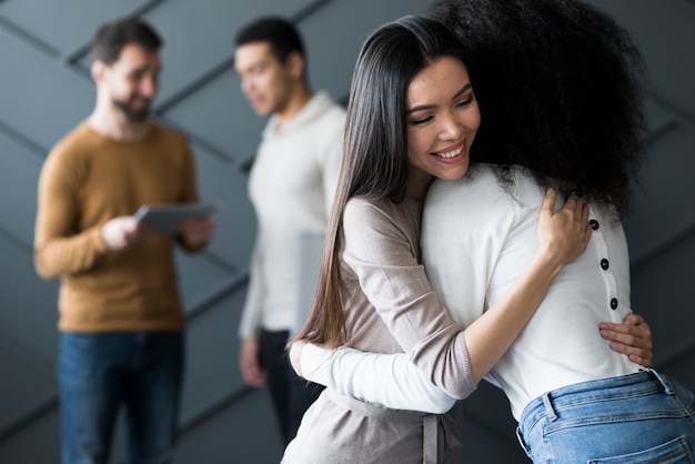 Vista frontal positiva jovens mulheres abraçando