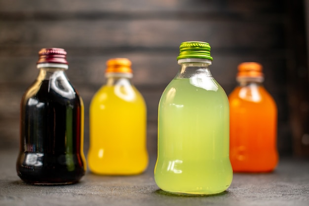 Foto grátis vista frontal preto amarelo verde e suco de laranja em garrafas
