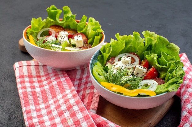 Vista frontal saborosa salada de vegetais com queijo pepino e tomate em fundo escuro