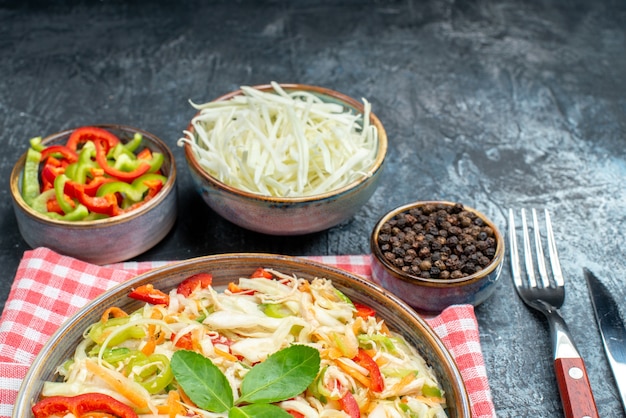 Vista frontal saborosa salada de vegetais com repolho fatiado e pimentão na mesa cinza