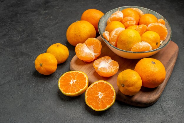 Vista frontal saborosas tangerinas suculentas dentro do prato no fundo cinza foto colorida de frutas cítricas exóticas laranja azeda
