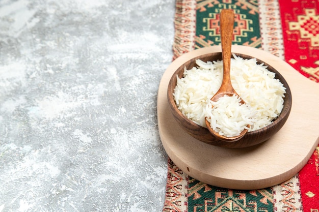 Vista frontal saboroso arroz cozido dentro do prato marrom no espaço em branco