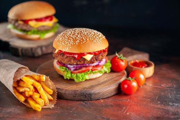 Vista frontal saboroso cheeseburger de carne com batatas fritas em fundo escuro jantar hambúrguer lanche fast-food salada prato torradas
