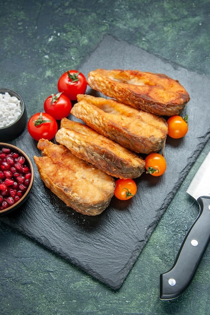 Vista frontal saboroso peixe frito com tomate na superfície azul escuro comida salada refeição carne frutos do mar mar cozinhar prato de fritura