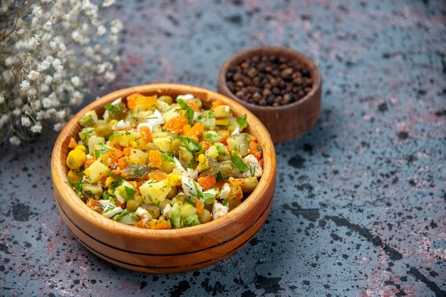 vista frontal salada de legumes cozida com pimenta no fundo azul