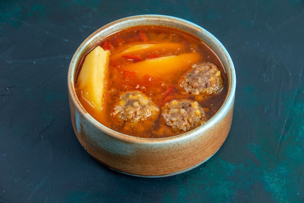 Vista frontal sopa de bolas de carne com batatas dentro de prato redondo na parede azul escuro comida sopa carne prato jantar vegetais