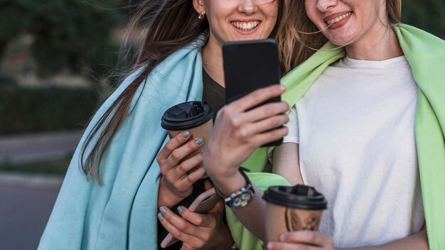 Vista frontal sorridente jovem mulher tirando uma foto