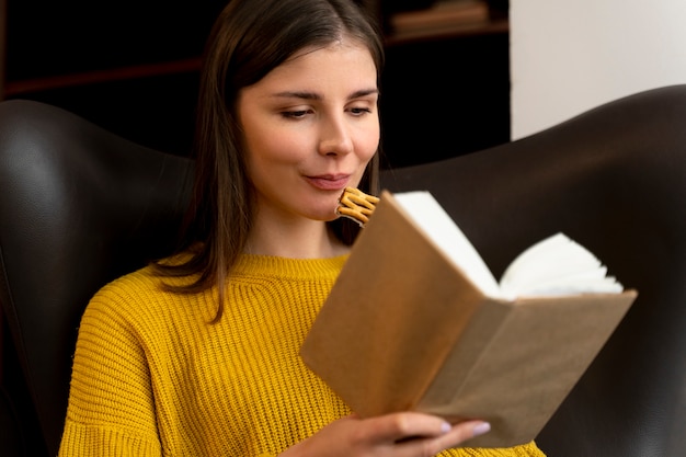Vista frontal sorridente mulher lendo livro