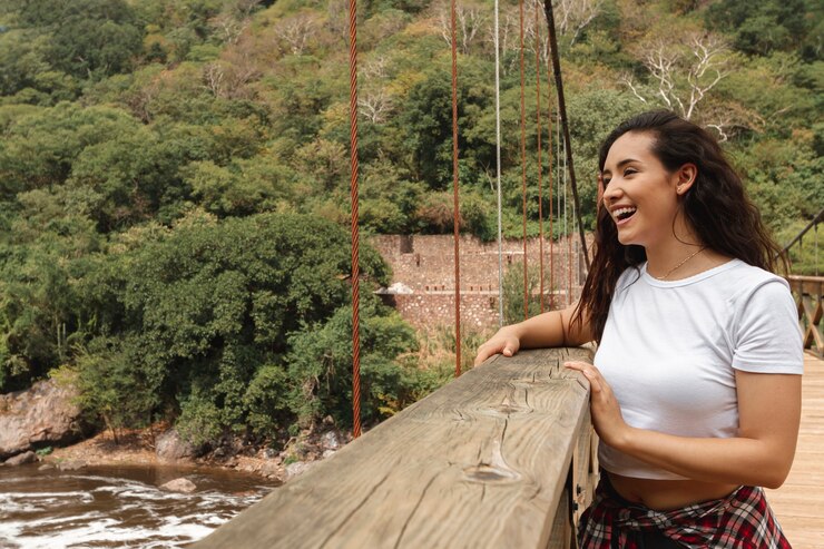Foto grátis vista frontal sorridente mulher olhando para o rio