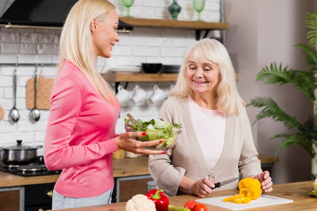 Vista frontal, tiro, de, mãe filha, segurando uma salada