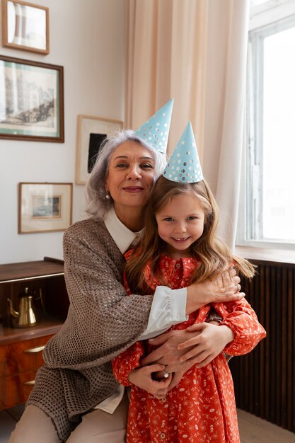 Vista frontal velha e menina comemorando aniversário