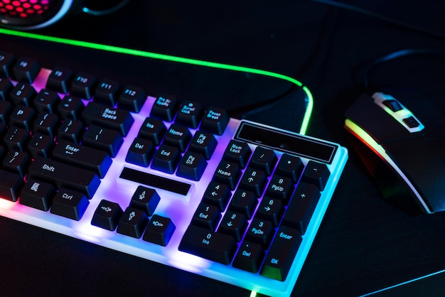 Vista gradiente da configuração da mesa de jogos de néon iluminada com teclado